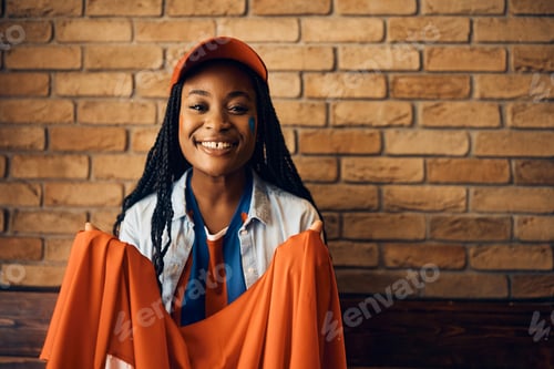 Preview: Smiling Woman Holding an Orange Cloth Indoors