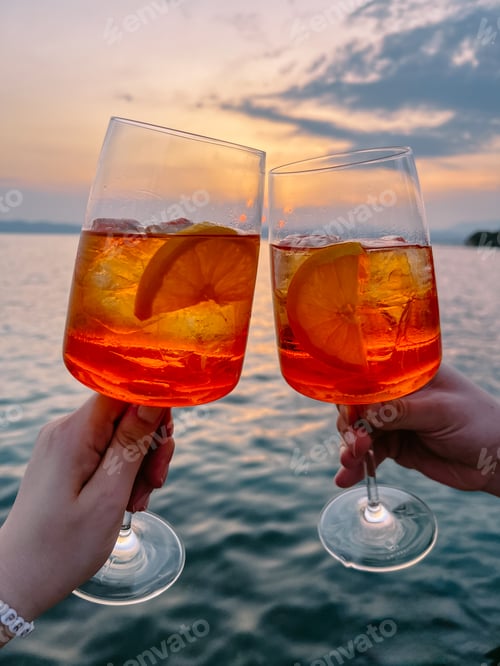 Celebratory Orange Cocktails Overlooking Lake at Sunset