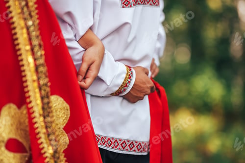 Preview: A guy and a girl dressed in national Russian clothes are holding hands Art grain and noise on photo