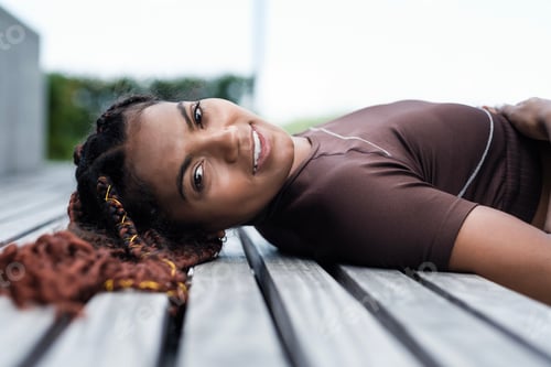 Preview: Portrait of young woman lying on a bench.