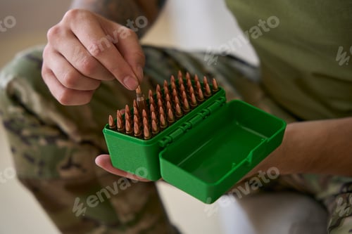 Preview: Man of arms removing single ammunition round from box