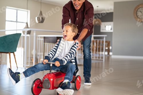 Preview: Playful grandfather pushing grandson toy car