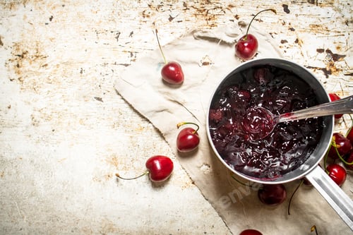 Preview: Cherry jam in a saucepan on the old fabric.