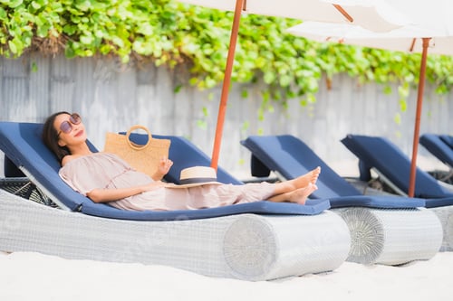 Preview: Portrait beautiful young asian woman on the deck chair with umbr