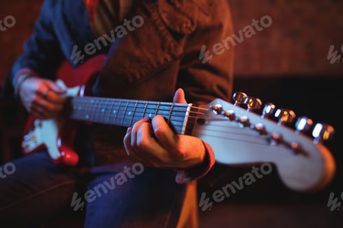Preview: Mid-section of man playing guitar