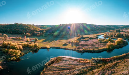 Preview: Road stretching between meadows and rivers under blue sky