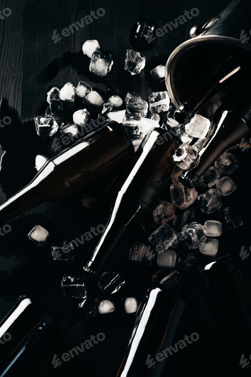 Preview: flat lay with bucket, glass bottles of beer and ice cubes arranged on dark tabletop