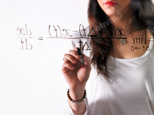 Preview: A young woman writing a mathematical equation with black marker on a clear seethrough surface.