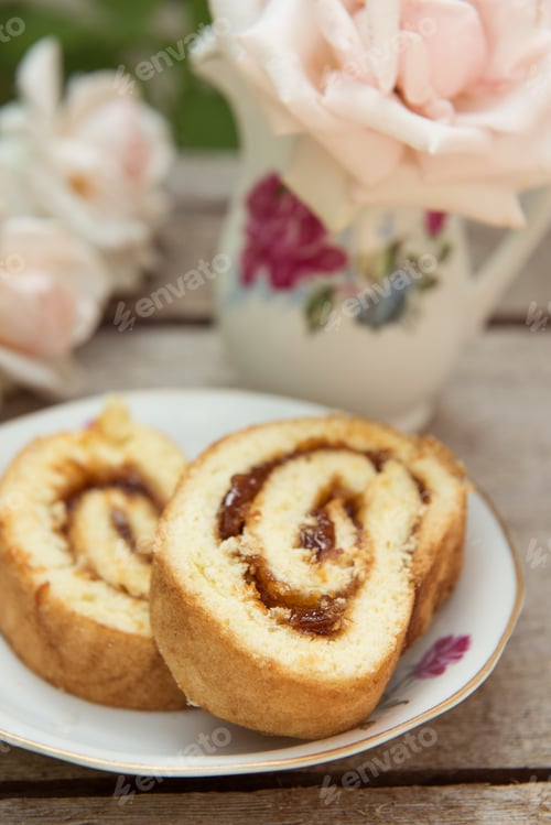 Preview: Biscuit roll with jam on old wooden background. Selective focus