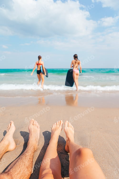 Preview: Closeup of the feet of family on the white sandy beach. Children play on the beach in shallow water