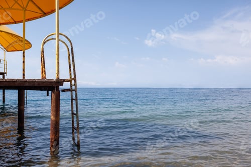 Preview: large pier with a roof and a rusty staircase descending into the water