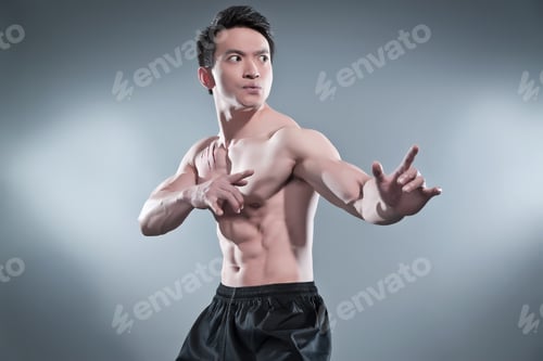 Preview: Muscled Asian Kung Fu Man In Action Pose. Blood Stripes On His Chest. Wearing Black Pants. Studio