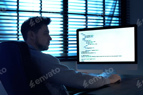 Preview: Man using computer in dark room. Criminal offence