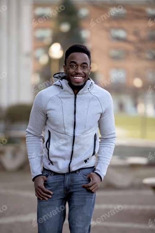 Preview: Portrait of a smiling African-American man in a park under sunlight with a blurry background