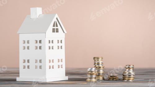 Preview: White toy model of house with white stacks of coins made of carton paper on grey table on pink