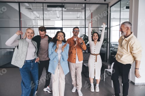 Preview: Cheerful diverse coworkers rejoicing over victory in office
