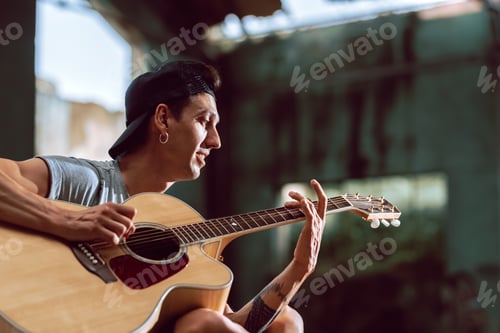 Preview: Young Man Plays Acoustic Guitar in Urban Setting