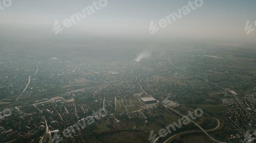 Preview: Aerial shot of a green city covered in fog