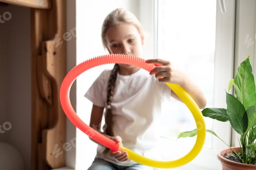 Preview: Girl Plays with a Colorful Corrugated Plastic Tube