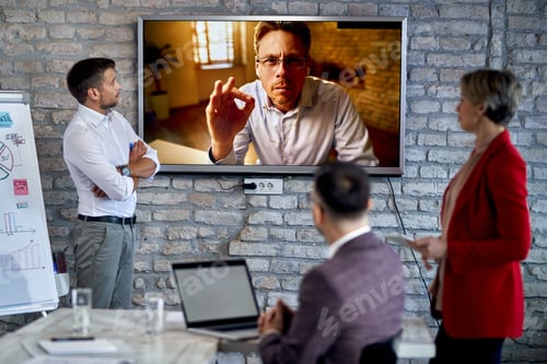 Preview: Mid Adult Businessman Talking With Is Team While Video Conferencing From Remote Location.