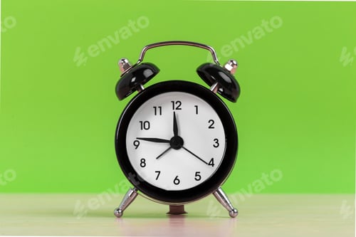Preview: Vintage black alarm clock on a bright green background
