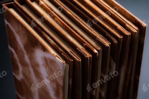 Preview: Pile of handmade notebooks isolated against black background