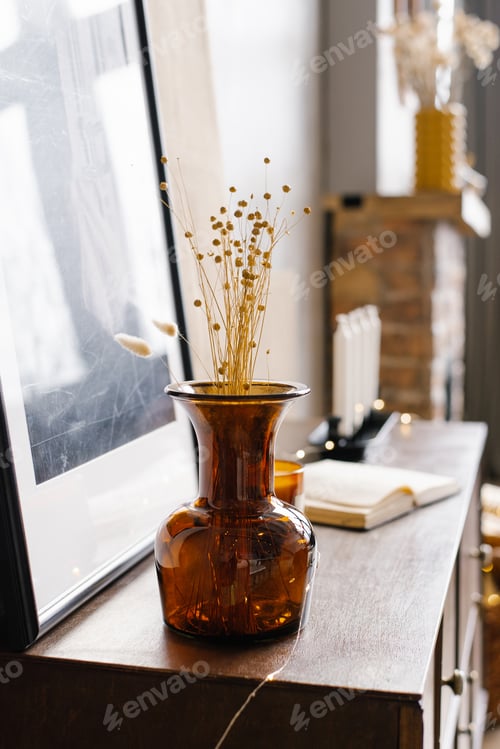 Preview: Brown glass vase with dried flowers in the interior of a modern house