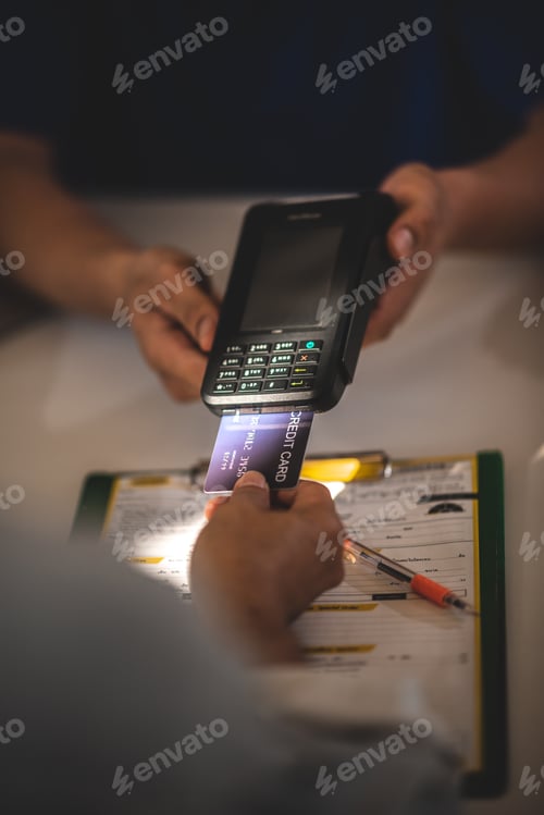 Preview: customer paying for services repair by debit or credit card while salesman holding NFC card machine