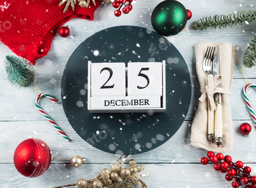 Preview: Christmas festive table setting with decor and blue plate with calendar date December, 25.
