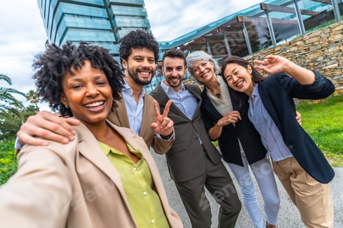 Preview: Business colleagues gesturing success while taking selfie together outdoors