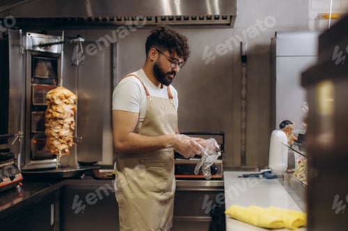 Preview: Chef preparing food with gloves in restaurant kitchen