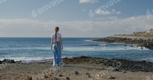 Visualização: Jovem mulher apreciando a vista do Oceano Atlântico. Litoral vulcânico, Puerto de Santiago