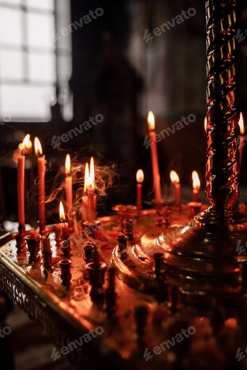 Preview: Candles in the dark of a church. selective focus. noise is present