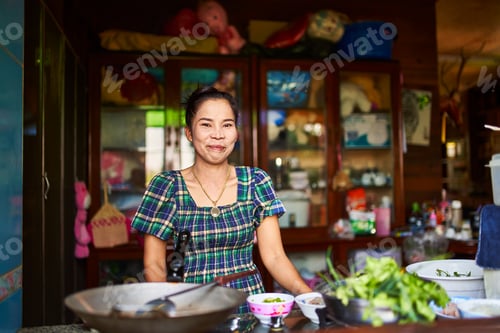 Preview: portrait of thai woman in traditional home kitchen ready to cook food