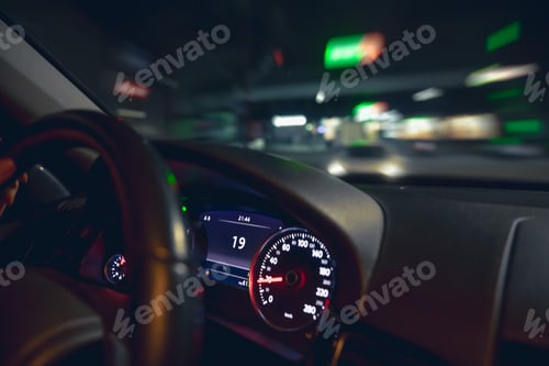 Preview: Car steering wheel and view of the night road from the car, close-up.