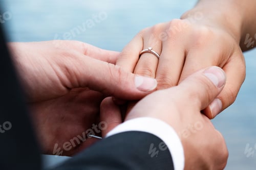 Preview: Closeup shot of the hands of a couple with an engagement ring - love concept