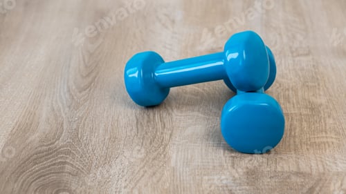 Preview: A blue dumbbell for doing sport on the floor at house indoor, healthy lifestyle