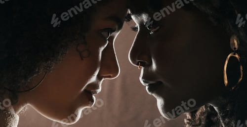 Preview: Cropped shot of a beautiful young female couple posing in studio against a dark background