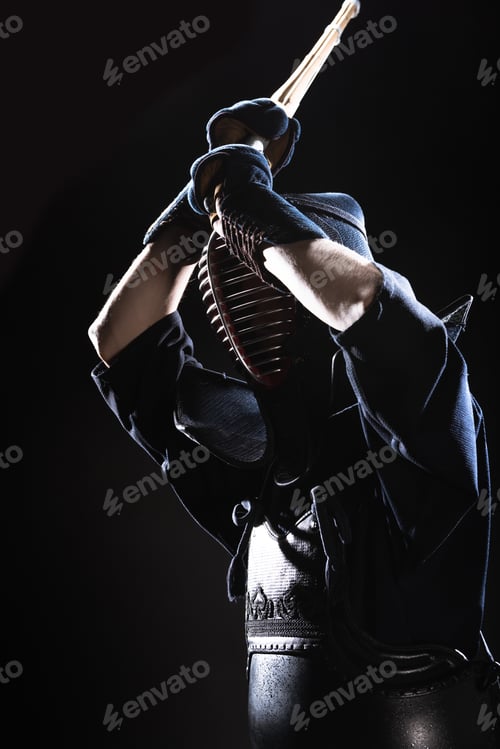 Preview: Kendo fighter in armor practicing with bamboo sword on black
