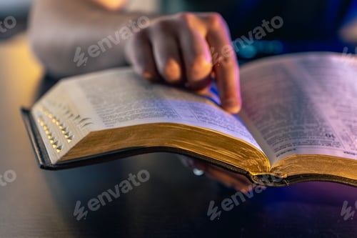 Visualização: A man reads the Bible. Male hands on the Holy Bible. Close-up of the Bible.
