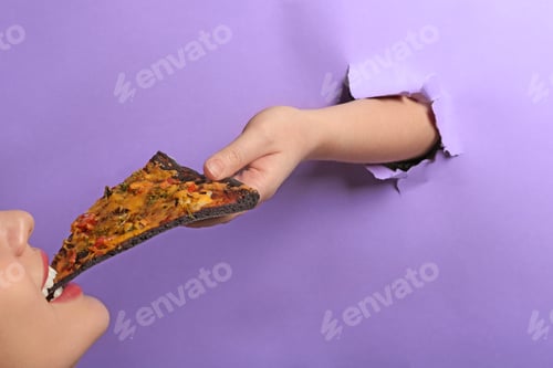 Preview: Person treating woman with black pizza through hole in color paper