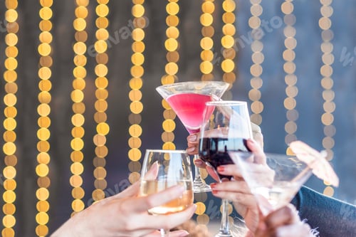 Preview: Hands toasting with drinks on a blurred light background