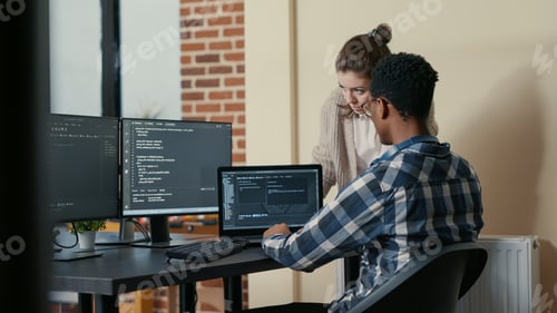 Preview: Two programmers doing high five hand gesture at desk with multiple screens running code celebrating