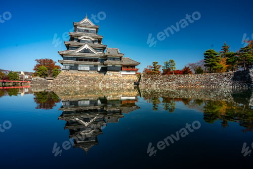 Preview: A large building with a tower and a large body of water in the background