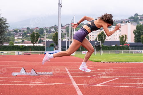 Preview: Athletic woman starting sprint at stadium