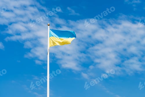 Preview: Flag of Ukraine against a blue sky with clouds. The national flag flutters in the wind.