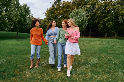 Preview: Four stylish friends confidently enjoying a spring day in a vibrant park