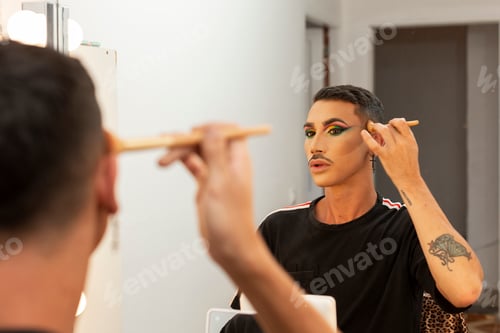 Preview: young drag queen artist doing her makeup in the dressing room