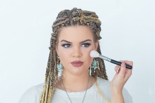 Preview: Professional makeup artist working with beautiful young woman. bright blonde model