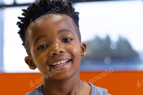 Preview: Smiling boy in school classroom, looking at camera with cheerful expression, copy space